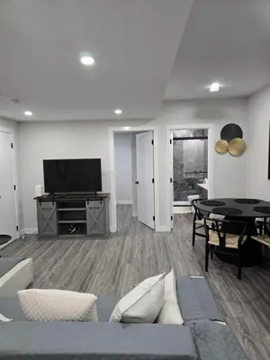 a living room with a couch and a tv at The Willow Nest lower suite-2 Rooms in Calgary