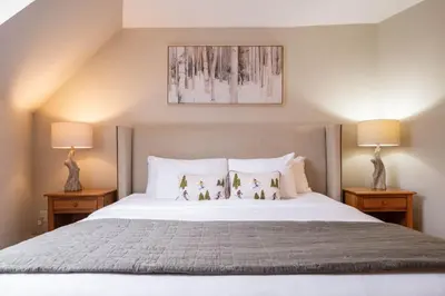 a bedroom with a large white bed with two lamps at Marquise 610 by Outpost Whistler in Whistler