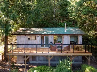 a house on a wooden deck with a porch at Ocean Vista In the Woods on Saltspring Island in Salt Spring Island