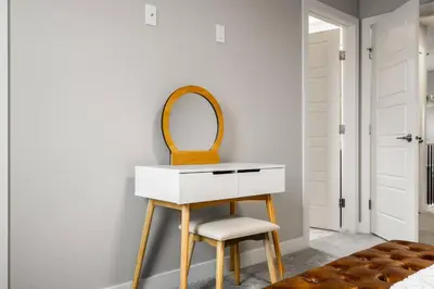 a dressing table with a mirror and a stool at Cowboy Chalet SE|AC|Games|King Bed|20 min to DT in Calgary