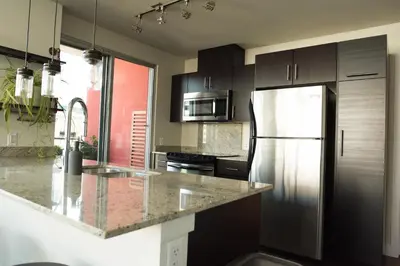 a kitchen with a stainless steel refrigerator and cabinets at City Views Walk to Calgary Tower and Stampede in Calgary