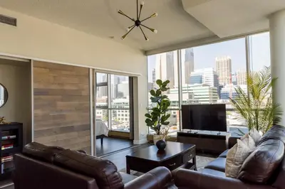 a living room with leather furniture and a large window at City Views Walk to Calgary Tower and Stampede in Calgary