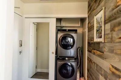 a laundry room with a washer and dryer in it at City Views Walk to Calgary Tower and Stampede in Calgary