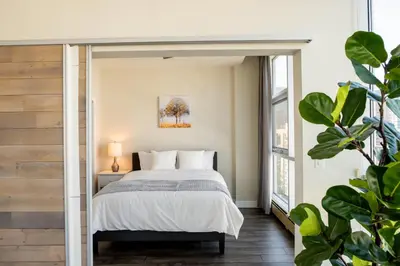 a bedroom with a bed and a window at City Views Walk to Calgary Tower and Stampede in Calgary