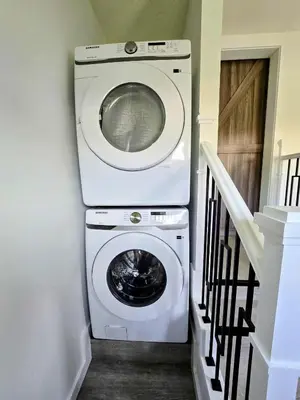 a washer and dryer in a room with a staircase at The Oasis in Stettler! in Stettler