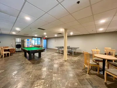 a room with ping pong tables and chairs at High Tide Suite - New Bright Oceanfront Escape with Spa-like Bath in Nanoose Bay