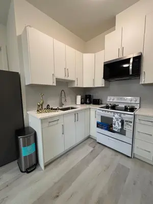 a kitchen with white cabinets and a stove top oven at South surrey Secondary Suite with Kitchen in Surrey