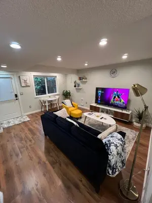 a living room with a black couch and a flat screen tv at Beautiful Entire 2 Bedroom Suite in Nanaimo