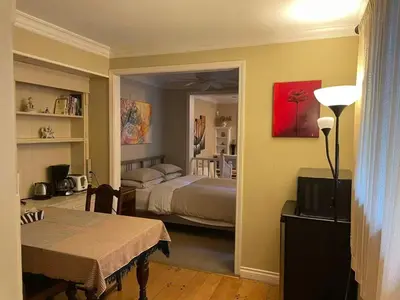 a room with a bedroom with a bed and a table at Suit near Grousmountain in North Vancouver