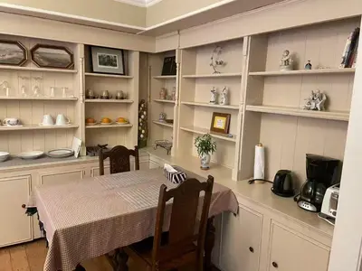 a kitchen with a table and shelves with dishes at Suit near Grousmountain in North Vancouver