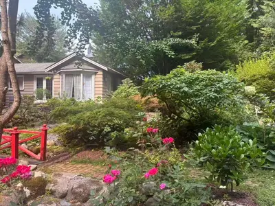 a garden with pink flowers and a house at Suit near Grousmountain in North Vancouver