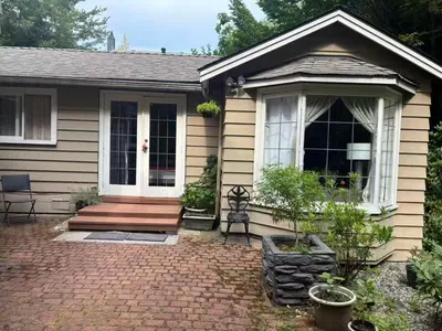 a small house with a wooden porch and a porch at Suit near Grousmountain in North Vancouver