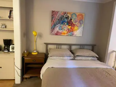 a bedroom with a bed and a painting on the wall at Suit near Grousmountain in North Vancouver