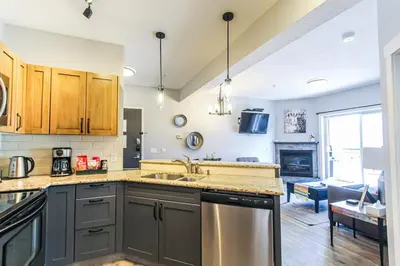 a kitchen with a sink and a stove at Cozy King Condo Mountain Views, Resort Perk and BBQ in Canmore