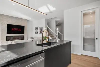 a kitchen with a sink and a fireplace at Luxury 7 Bedroom House with Karaoke Sound System and 100 Inch Projector in Calgary