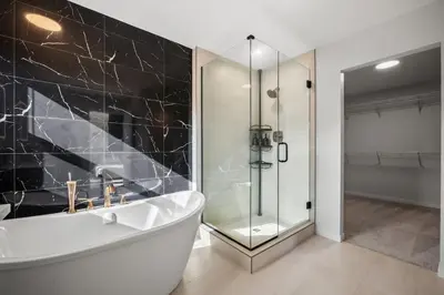 a bathroom with a tub and a glass shower at Luxury 7 Bedroom House with Karaoke Sound System and 100 Inch Projector in Calgary