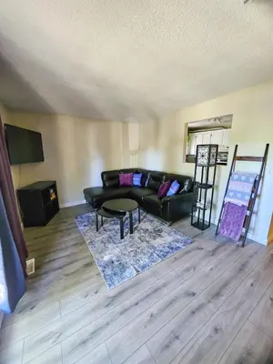 a living room with a black couch and a table at The Onyx Suite In Inglewood Minutes To DT in Calgary