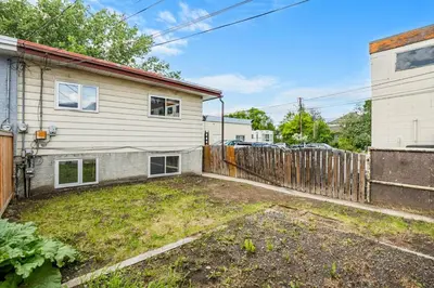 an empty yard in front of a house with a fence at The Onyx Suite In Inglewood Minutes To DT in Calgary