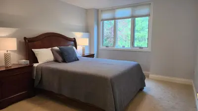 a bedroom with a large bed and two windows at Peaceful & Cozy Retreat by the Park in Calgary