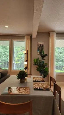 a dining room with a table with chairs and a plant at Peaceful & Cozy Retreat by the Park in Calgary