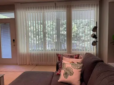 a living room with a couch and a large window at Peaceful & Cozy Retreat by the Park in Calgary