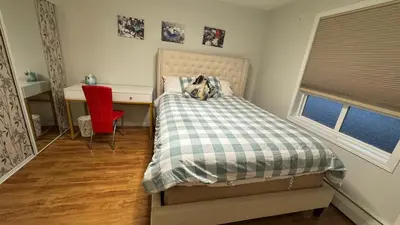 a bedroom with a bed and a desk and a red chair at Main Floor Condo Fully Independent 1 Bed 1 Bath in Edmonton