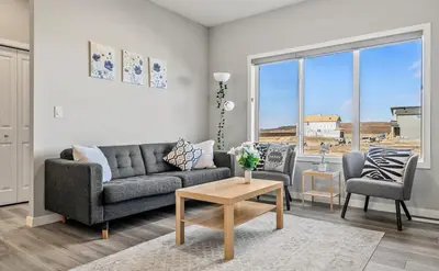 a living room with a couch and a table at Cozy 3-Bedroom Family Retreat Home in Rangeview in Calgary
