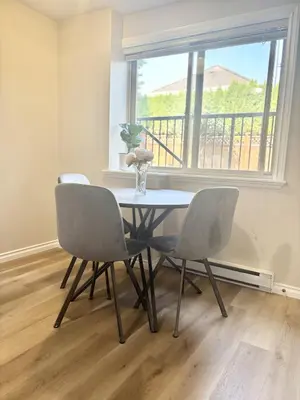 a dining room table with three chairs and a window at Bella Sweet Suite -Cozy 2B suite Morgan Creek in Surrey