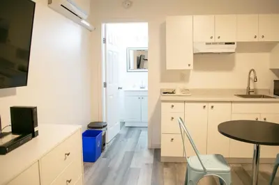 a kitchen with white cabinets and a table and a window at Westview Centre Motel Ltd in Powell River