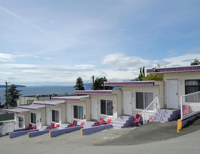a building with red chairs in front of it at Westview Centre Motel Ltd in Powell River
