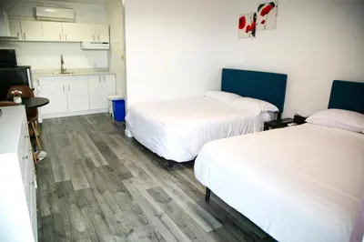 a room with two beds and a kitchen at Westview Centre Motel Ltd in Powell River
