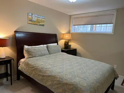 a bedroom with a bed with two night stands and a window at UBC Two-Bedroom Suite - Steps from Beach, Park & Golf - Full Kitchen in Vancouver