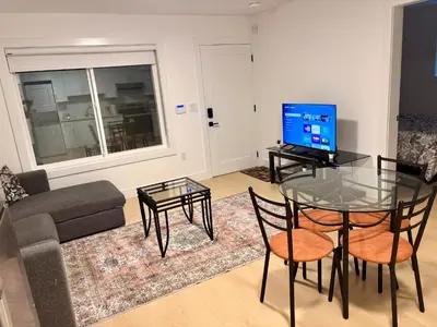 a living room with a glass table and a television at Cozy Private Suite in Langley in Langley