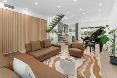 a living room with a couch and a piano at New Lux House on Vancouver West in Vancouver