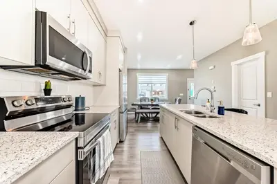 a large kitchen with a sink and a microwave at Cozyhub Vacation Rental Calgary-3Bedroom with AC in Calgary