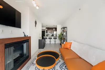 a living room with a couch and a fireplace at Modern Condo in Downtown Vancouver in Vancouver