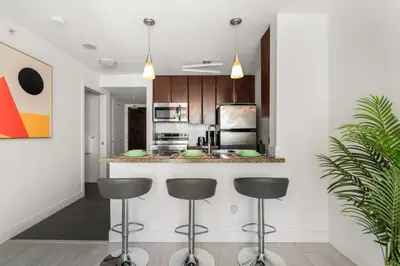 a kitchen with a counter and stools in a room at Modern Condo in Downtown Vancouver in Vancouver