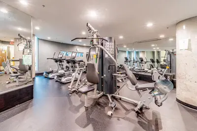 a gym with several tread machines in a room at Modern Condo in Downtown Vancouver in Vancouver