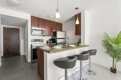 a kitchen with a counter and stools in it at Modern Condo in Downtown Vancouver in Vancouver
