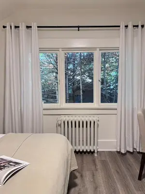 a bedroom with a bed and two windows at Modern Queen Room Ensuite Bathroom Vancouver West in Vancouver