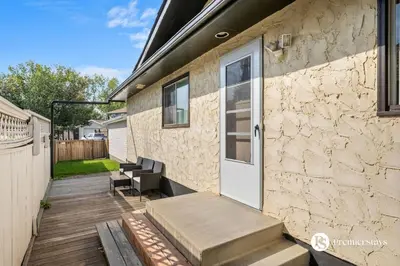 a stone house with a porch with a white door at Spacious Cozy Couples Getaway Basement Suite in Sundance in Calgary