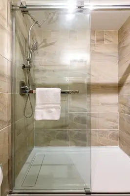 a shower with a glass door in a bathroom at Westwinds - Funky Basecamp in the Rockies in Canmore