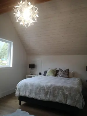 a bedroom with a large bed and a chandelier at Après-Ski Lodge in Agassiz