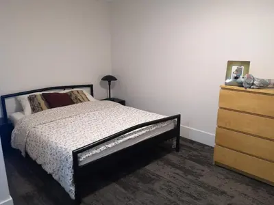 a bedroom with a bed next to a dresser at Après-Ski Lodge in Agassiz