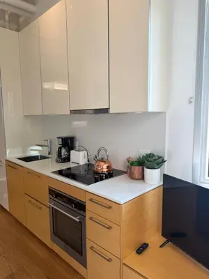 a kitchen with white cabinets and a stove top oven at Downtown Studio Rental in Victoria