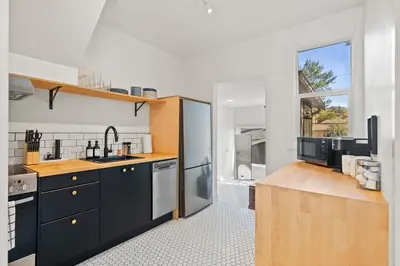 a kitchen with a sink and a refrigerator at The Sunny 2 Suites 10 Pax Pet Friendly Stay in Calgary