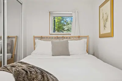 a bedroom with a bed with white sheets and a window at The Sunday Charming Private Suite in Calgary in Calgary