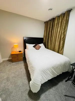 a bedroom with a white bed and a window at Modern 2-bed 1-bath Suite in Calgary
