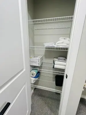 a walk in closet with white shelves and towels at Modern 2-bed 1-bath Suite in Calgary