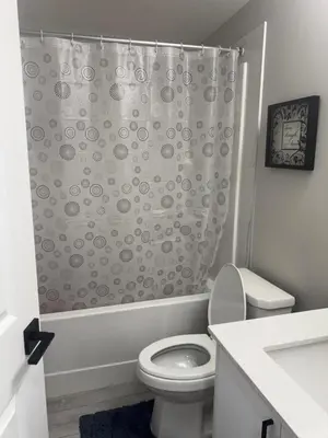 a bathroom with a toilet and a shower curtain at Modern 2-bed 1-bath Suite in Calgary